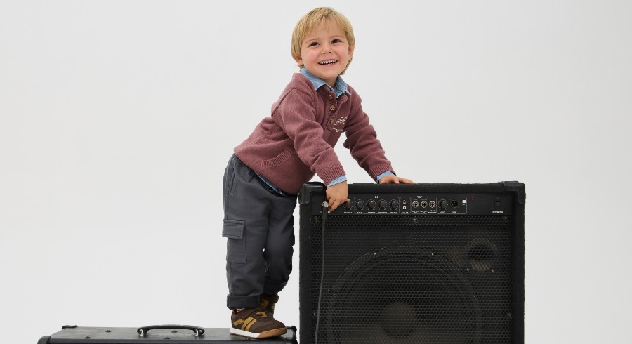 Niño parado arriba de amplificadores con polerón